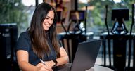Frau am Laptop im Fitnessstudio