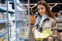 Frau kauft Hühnereier im Supermarkt